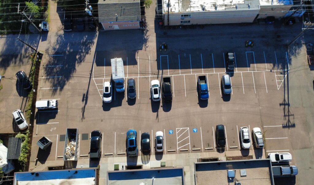 Aerial view of a fully striped downtown parking lot with rows of stalls and an ADA access aisle