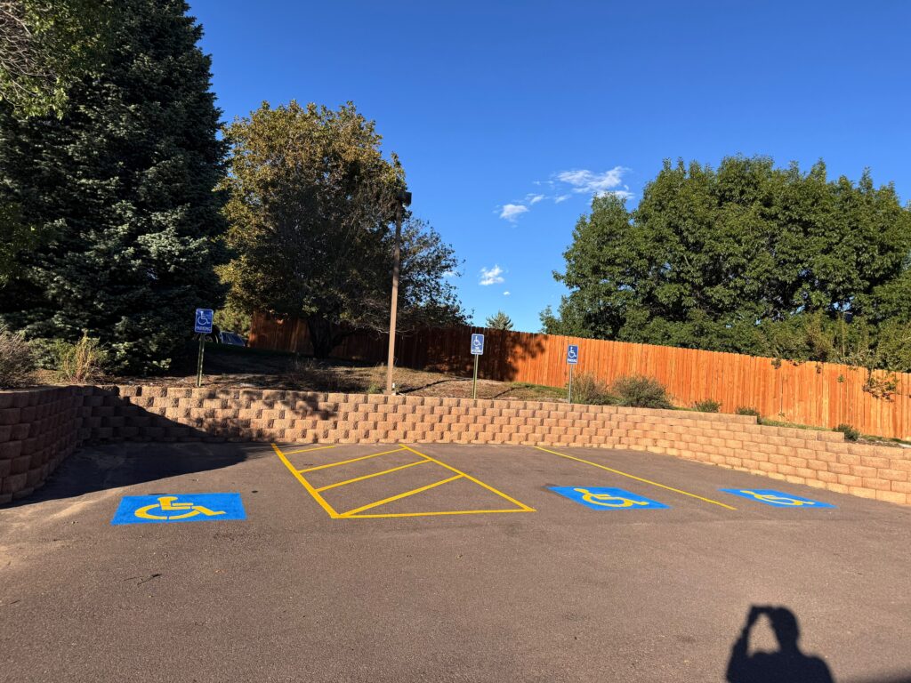 ADA handicap parking stalls with a hatched yellow access aisle beside a retaining wall